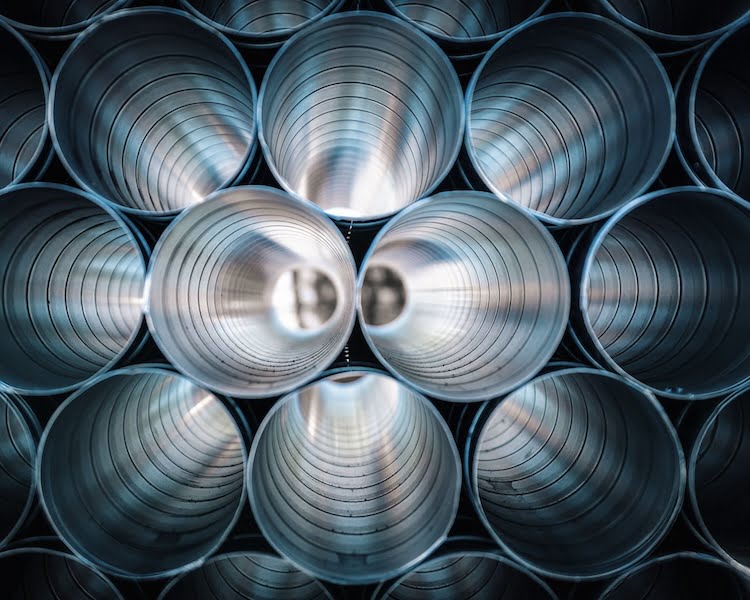 large-silver-pipes-stacked-at-factory